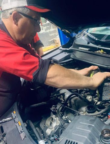 Jon of GLP Automotive, performing an engine repair on a vehicle