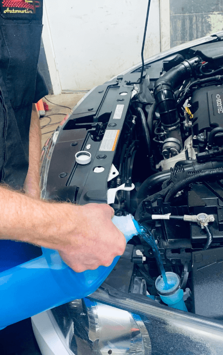 A GLP Automotive technician filling up the fluids in a car at GLP Automotive in Lake Geneva, WI | oil change and fluid services