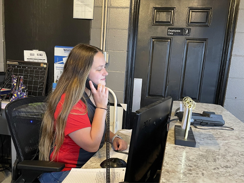 Dakota of GLP Automotive, talking on the phone at a desk.